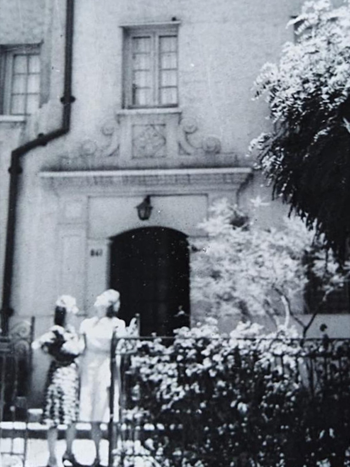 Fachada de Triana 861 con dos mujeres frente a la entrada, años 40-50